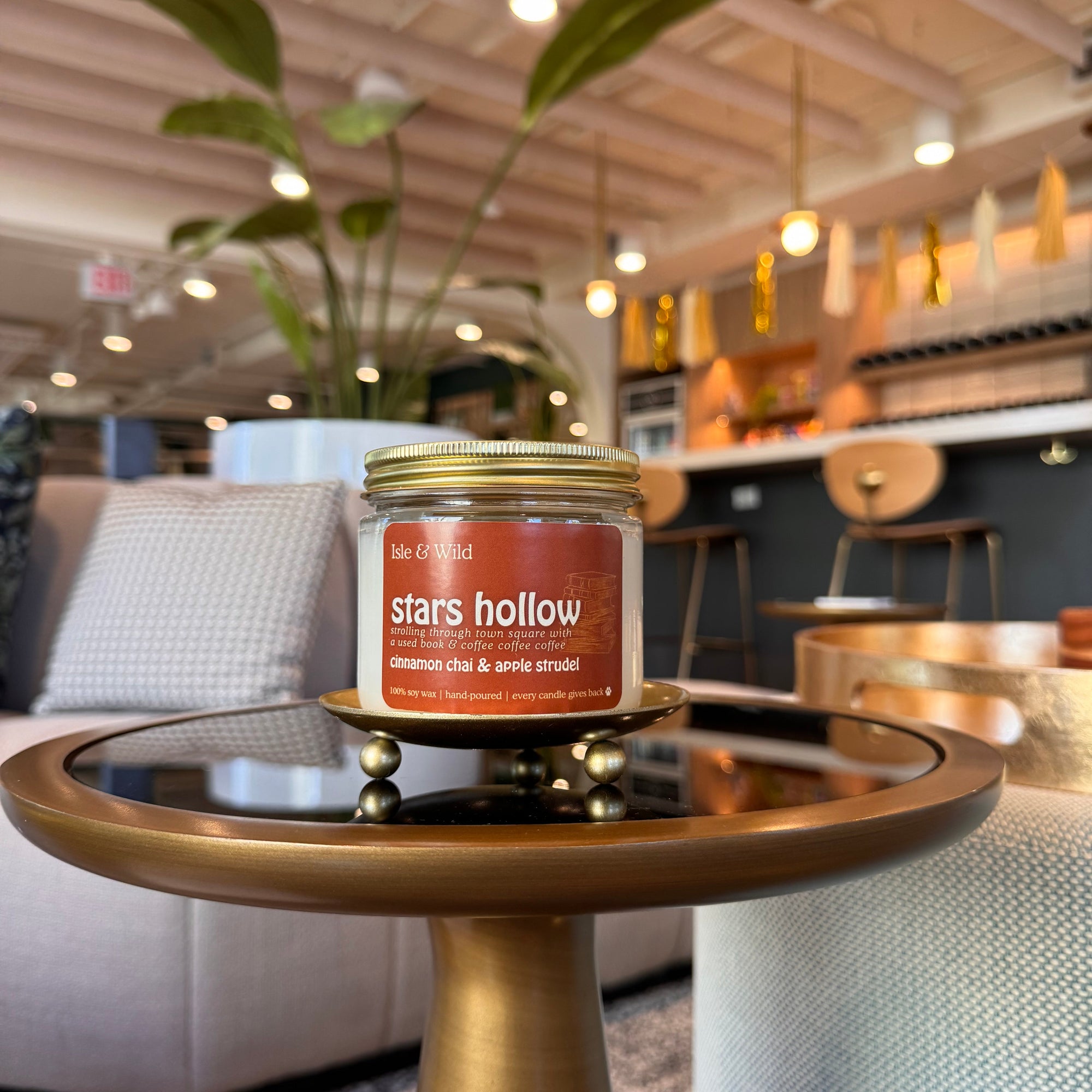 Candle labeled 'Stars Hollow' on a surface with a blurred indoor background